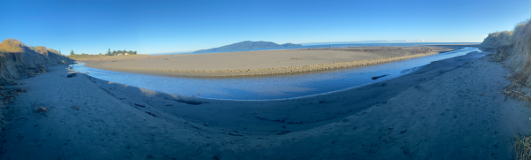View of Waimeha Stream’s position on Waikanae Beach, seen from the dune near Field Way and facing west toward the sea, with Kāpiti Island visible on the horizon.