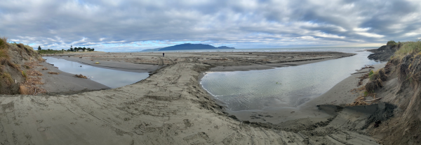 View of Waimeha Stream’s position on Waikanae Beach, seen from the dune near Field Way and facing west toward the sea, with Kāpiti Island visible on the horizon.