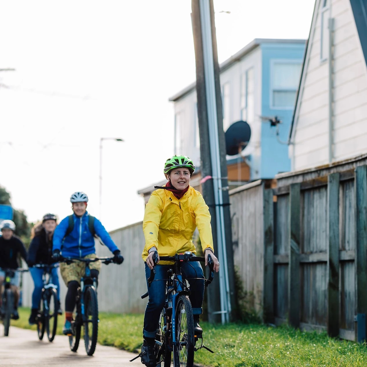 A row of people cycle down a city street