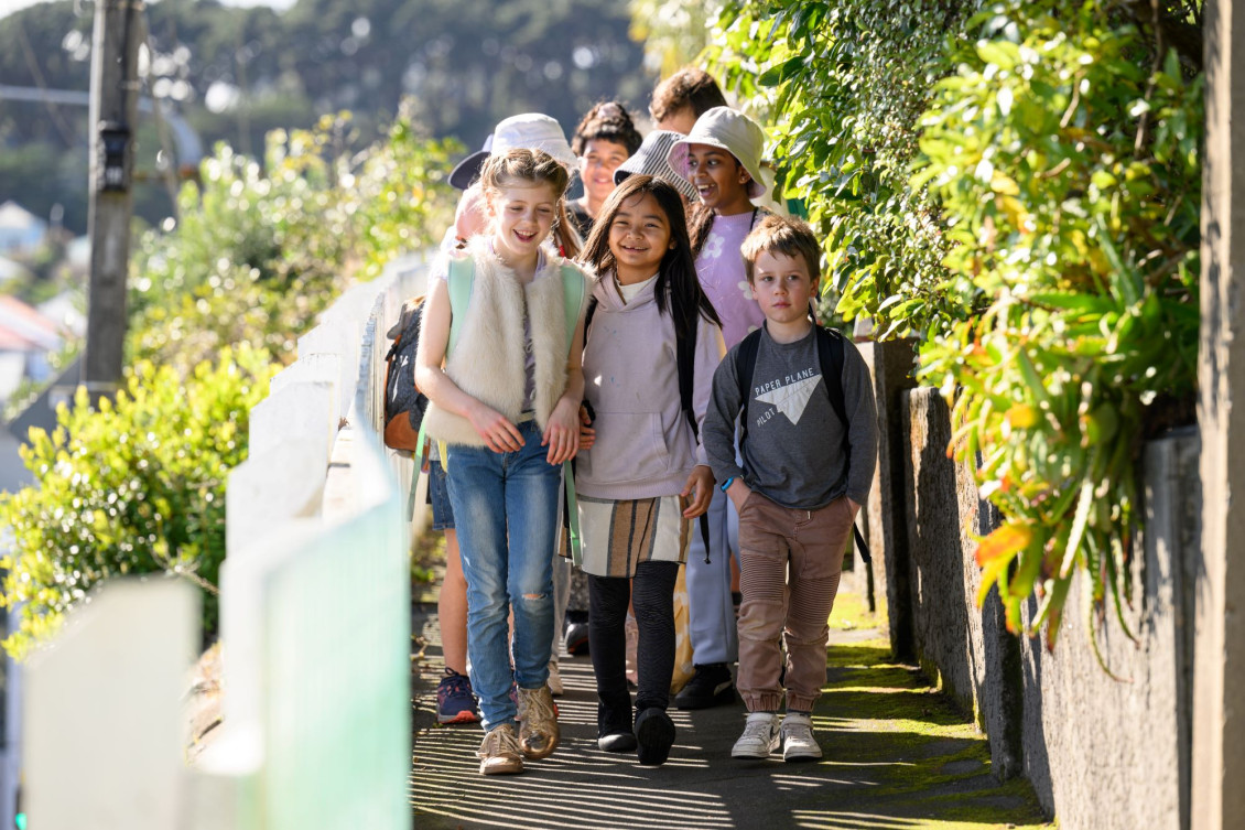 A group of children in a walking school bs walk down the footpath