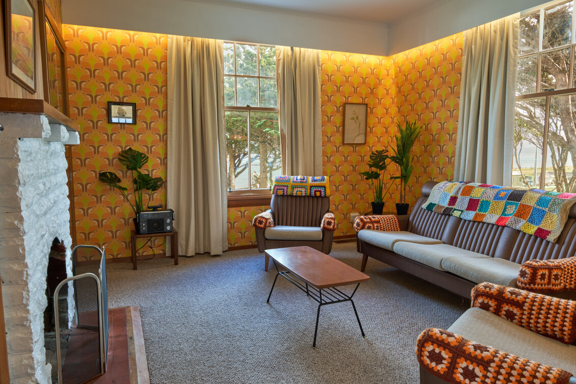 The living room of the lightkeeper's assistant cottage, decorated in a warmly-coloured 70s theme
