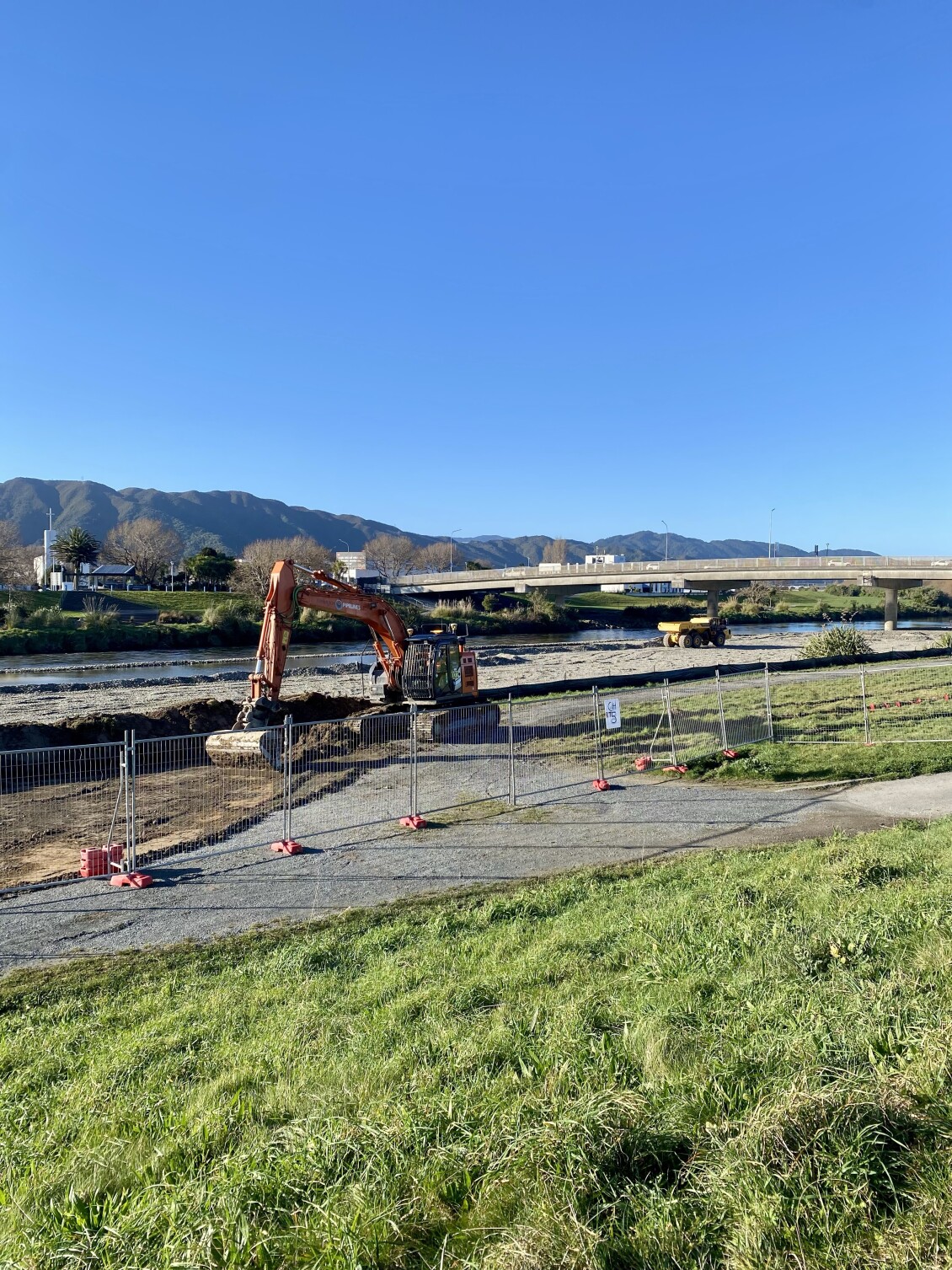 A digger working on a temporary rockline on the bank of Te Awa Kairangi/Hutt River for flood protection