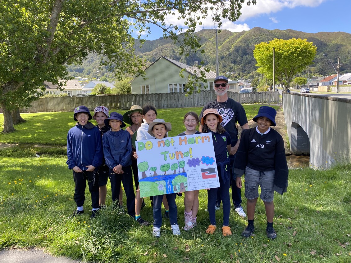 Students and a teacher from Naenae Primary School show off their "Do not harm tuna" sign